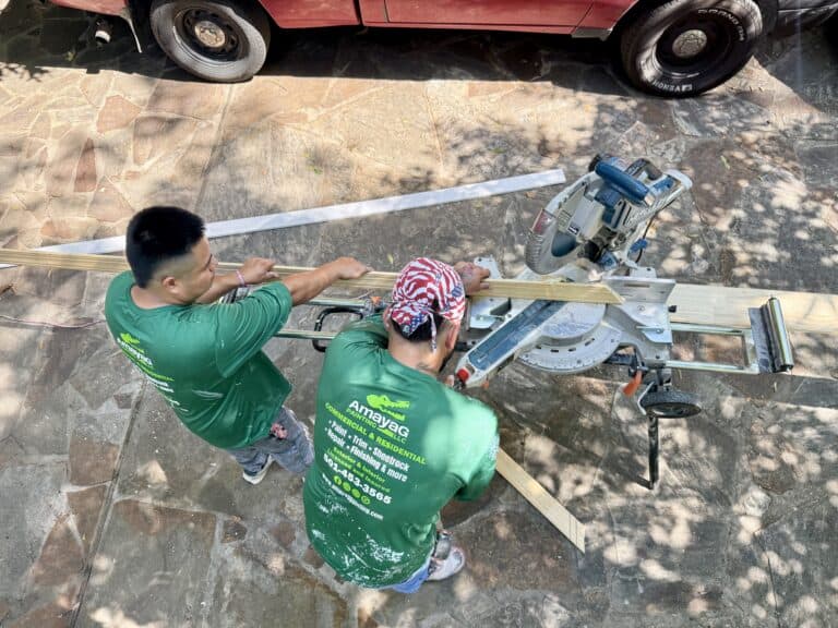 Amaya G Painting crew cutting finish trim on a miter saw