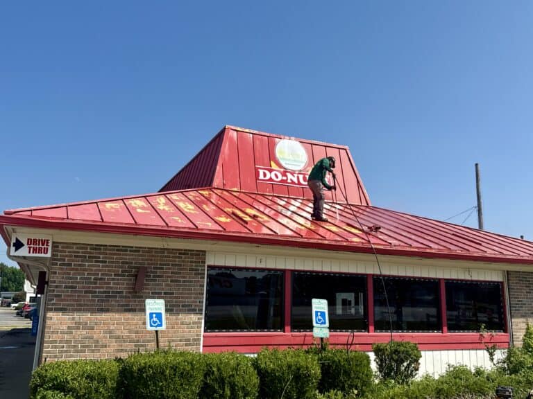 Finished exterior painting on a local donut shop with a red metal roof